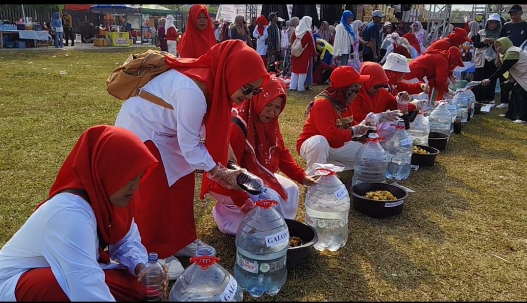 Peserta berjajar di atas rumput Lapangan Merdeka menakar bahan eco enzyme ke dalam galon. Meski matahari mulai terik, peserta tetap bersemangat menuntaskan racikannya. Foto: Panitia HUT RI